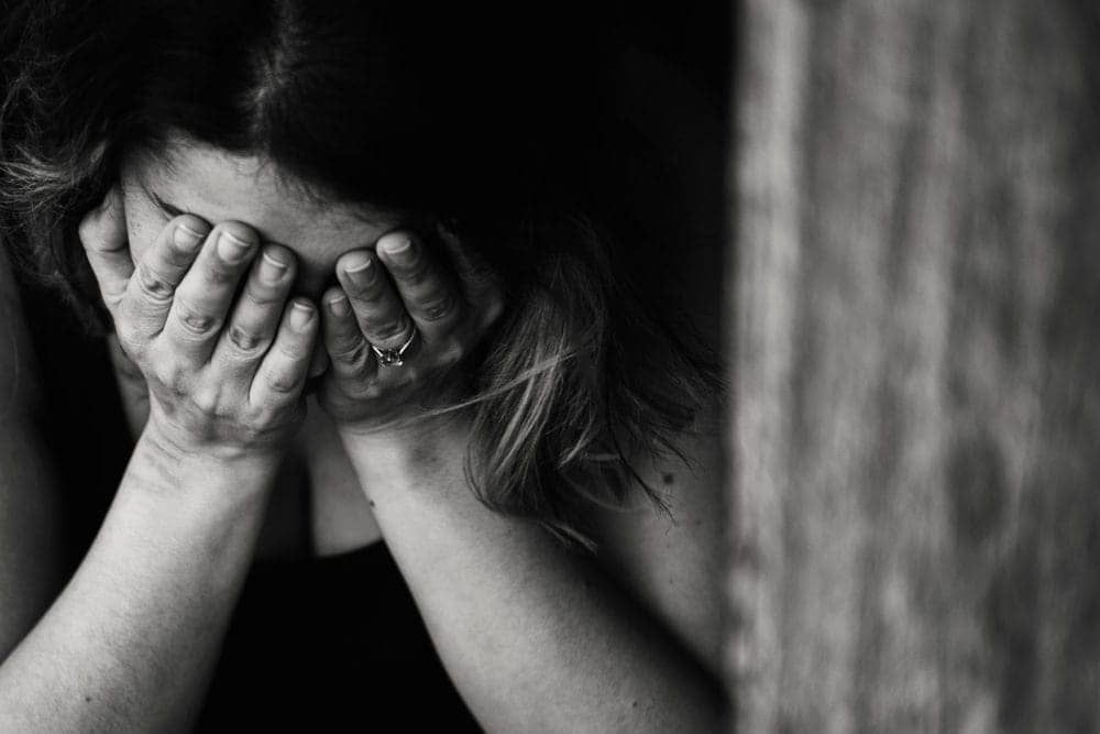 grayscale woman with head in her hands