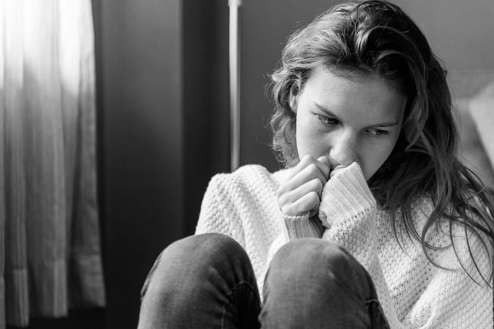young girl covering mouth with hands sick from drug addiction