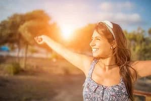 teen girl smiling with outstretched arms after holistic addiction therapy program